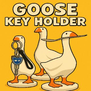 Three white goose key holders with orange beaks and feet, one holding a key ring and another with a spoon in its beak.